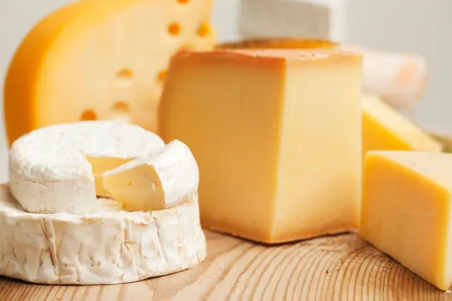 Various cheeses displayed on a wooden surface.